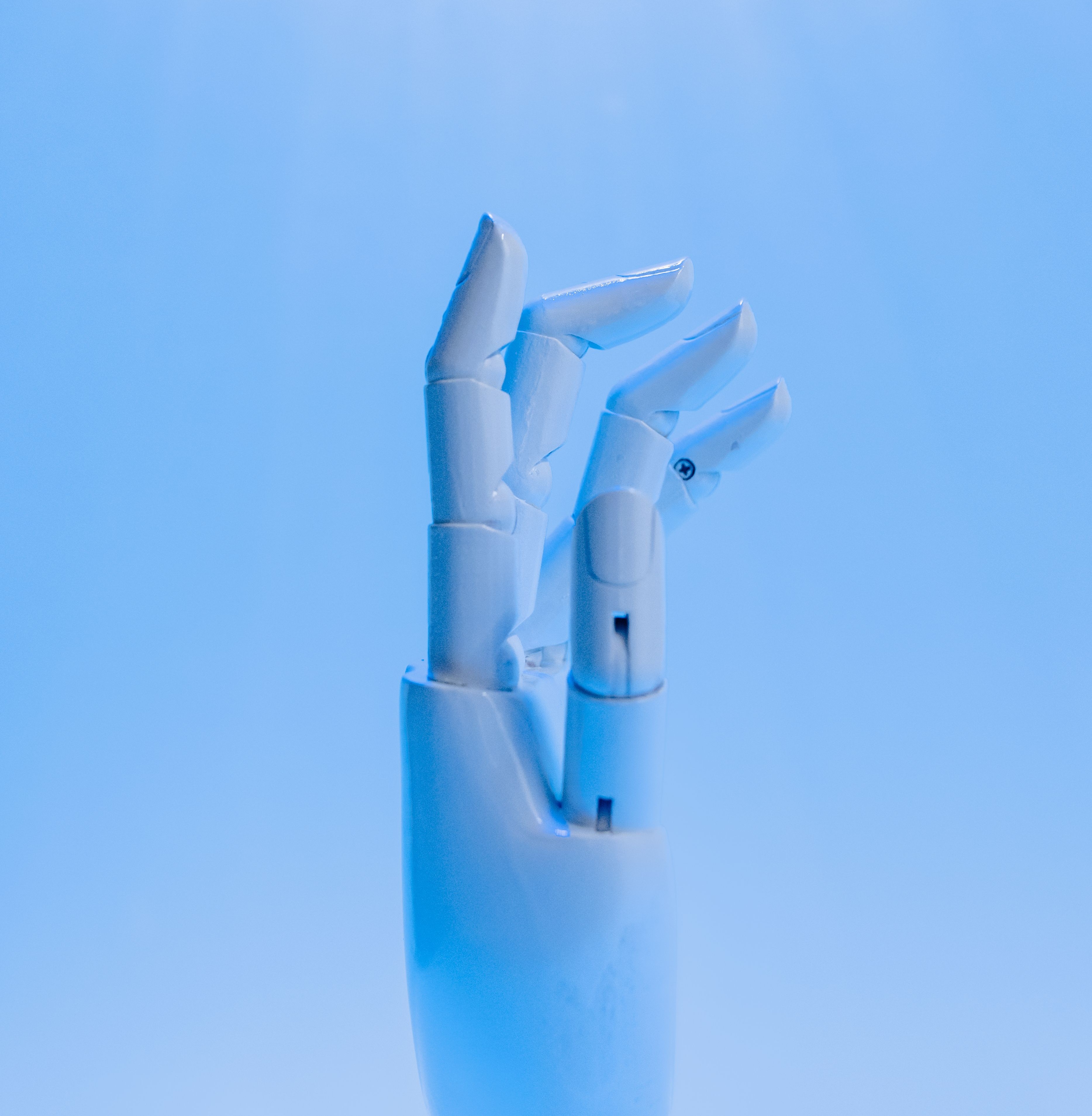 Mano robótica sobre fondo azul, símbolo de innovación